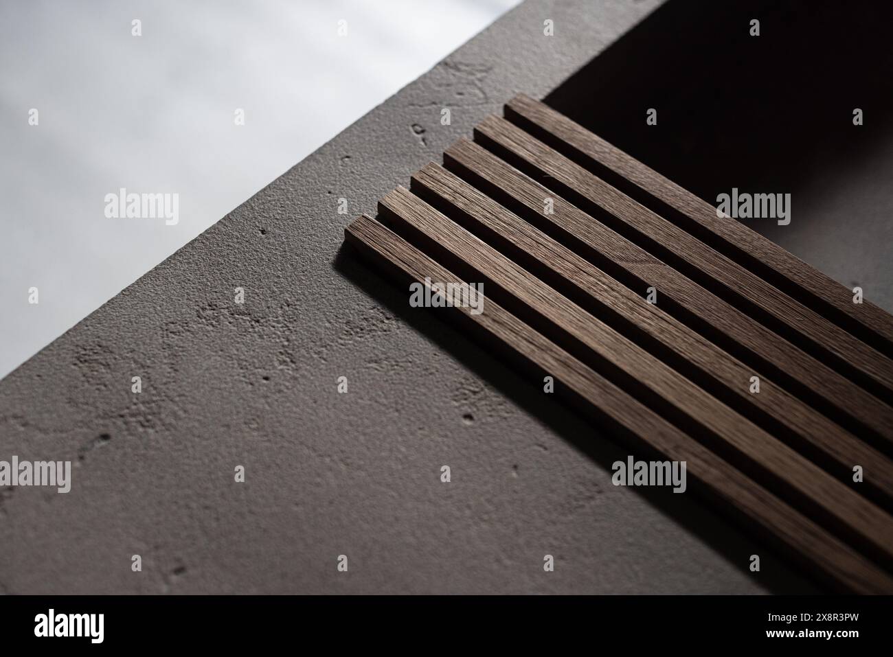 Spranghe in legno su una superficie in cemento con illuminazione soffusa Foto Stock