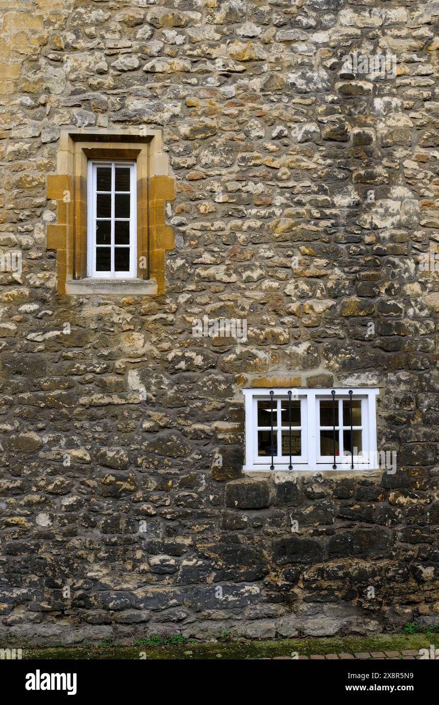 Una vecchia e una nuova finestra collocata in un vecchio muro nel centro di Oxford Foto Stock