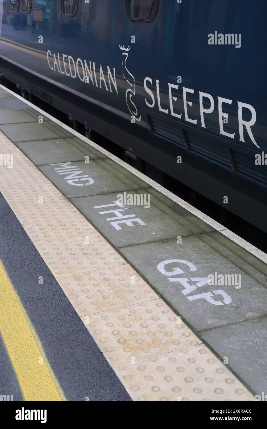 Il cartello Caledonian Sleeper and Mind the Gap sul binario 3 della stazione della Cittadella di Carlisle. Foto Stock