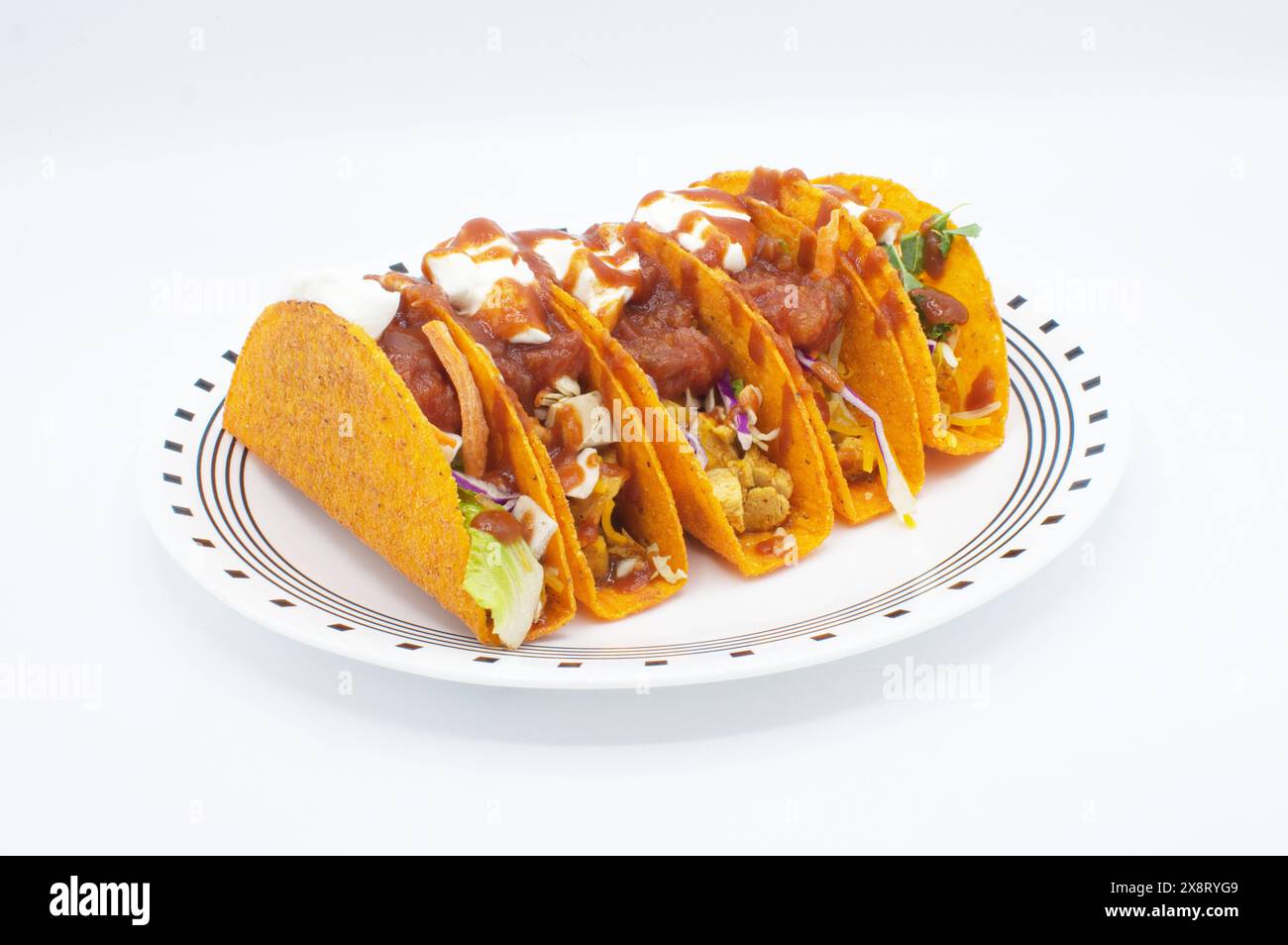tacos messicani di pollo grattugiato e a pezzi con pomodoro, lattuga, cavolo, ingredienti a base di panna acida e nacho al gusto di gusci duri. Isolato su un whi Foto Stock