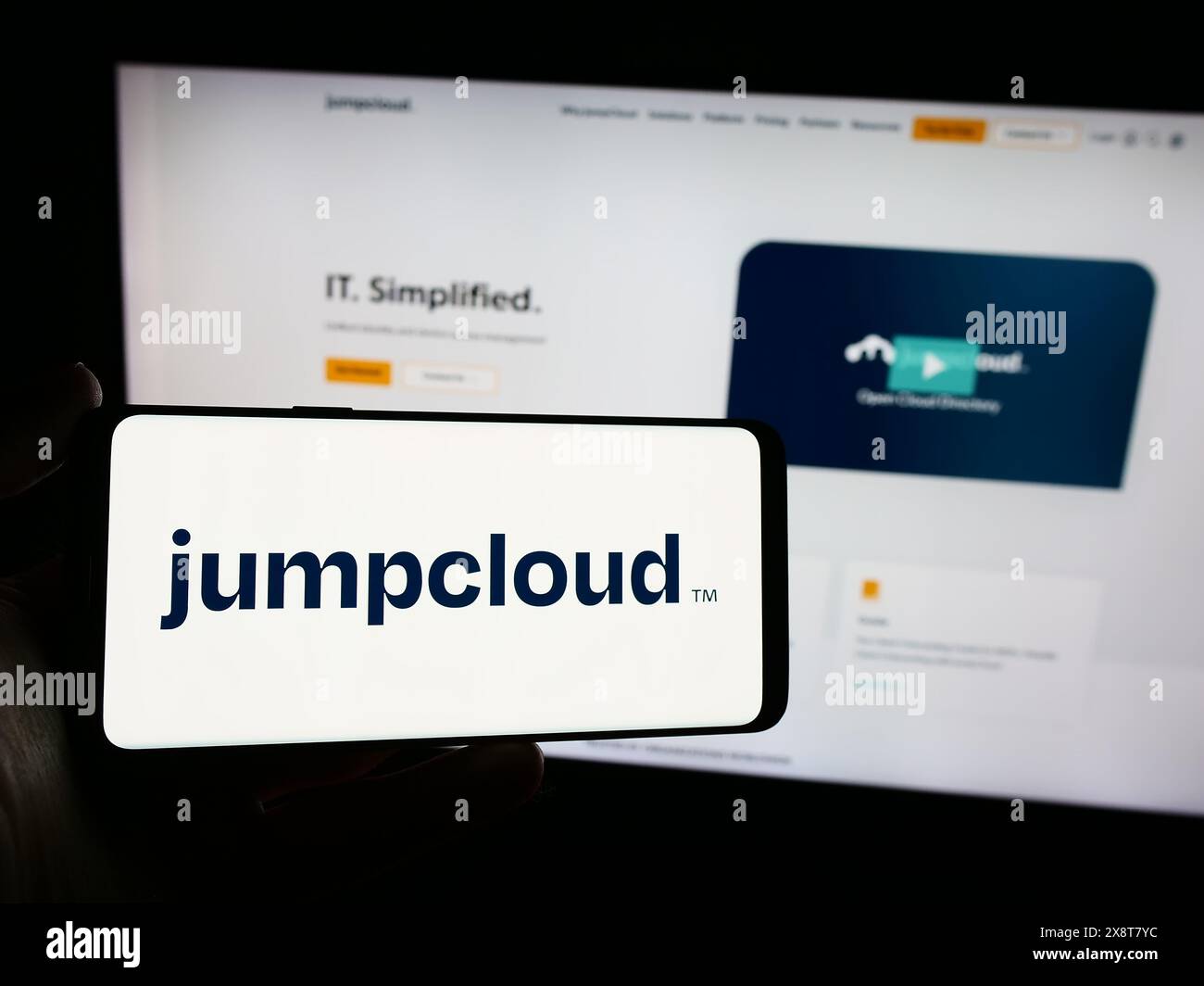 Persona che possiede uno smartphone con il logo della società di software cloud statunitense JumpCloud Inc. Davanti al sito Web. Mettere a fuoco il display del telefono. Foto Stock