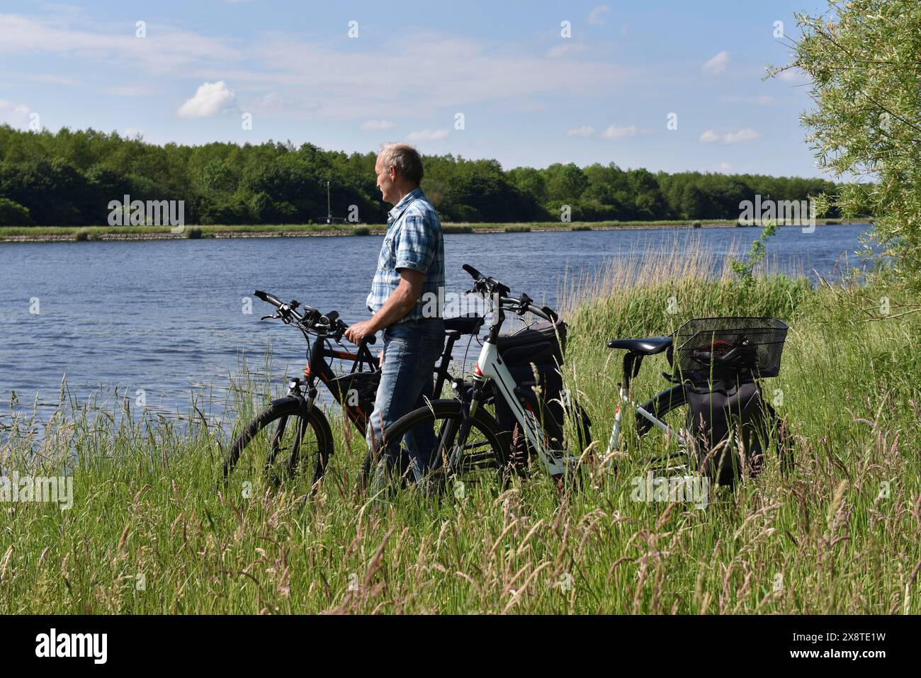 Ciclismo senior lungo il canale Kiel, Kiel Canal, Schleswig-Holstein, Germania Foto Stock
