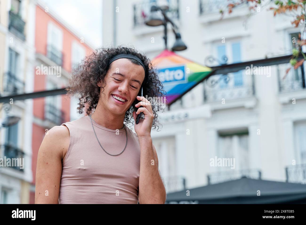 persona gay in abiti femminili che parla sullo smartphone Foto Stock