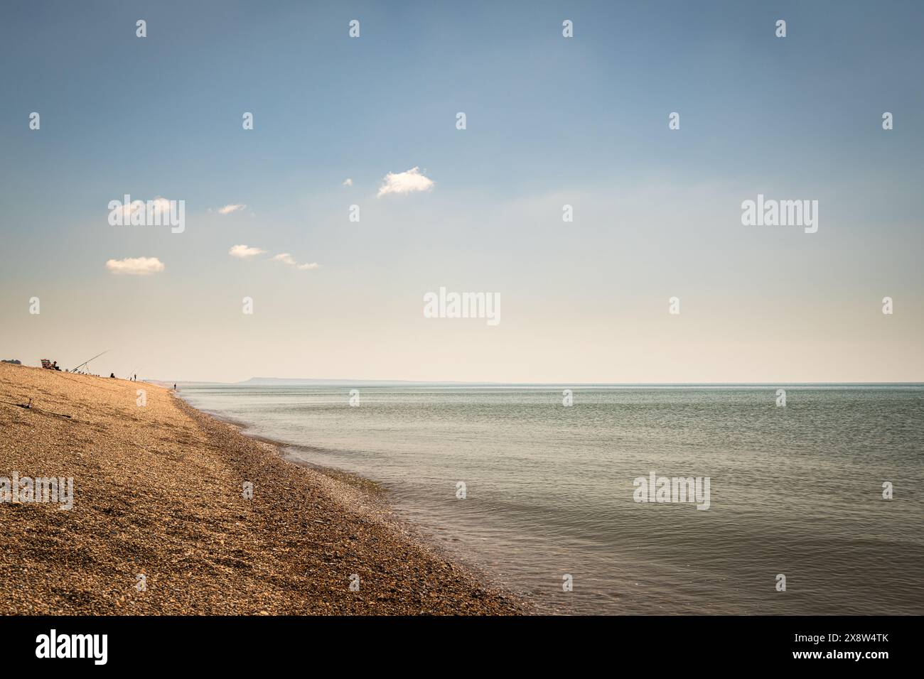 Un'immagine HDR estiva di sole persone che pesca al largo di Chesil Beach, con Porland Bill in lontananza, nel Dorset, in Inghilterra. 20 maggio 2024 Foto Stock