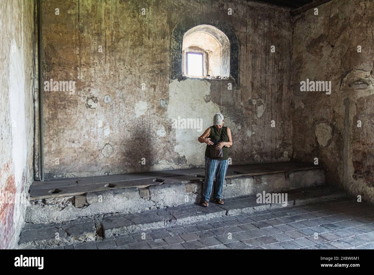 Yuriria, Messico, 26 maggio 2024: Donna in posa accanto alle latrine che i monaci usavano 400 anni fa. Foto Stock