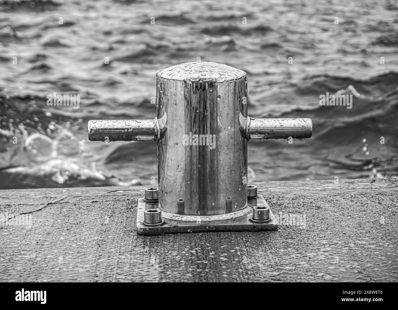 Vista delle onde del mare e del bollard in mare Foto Stock