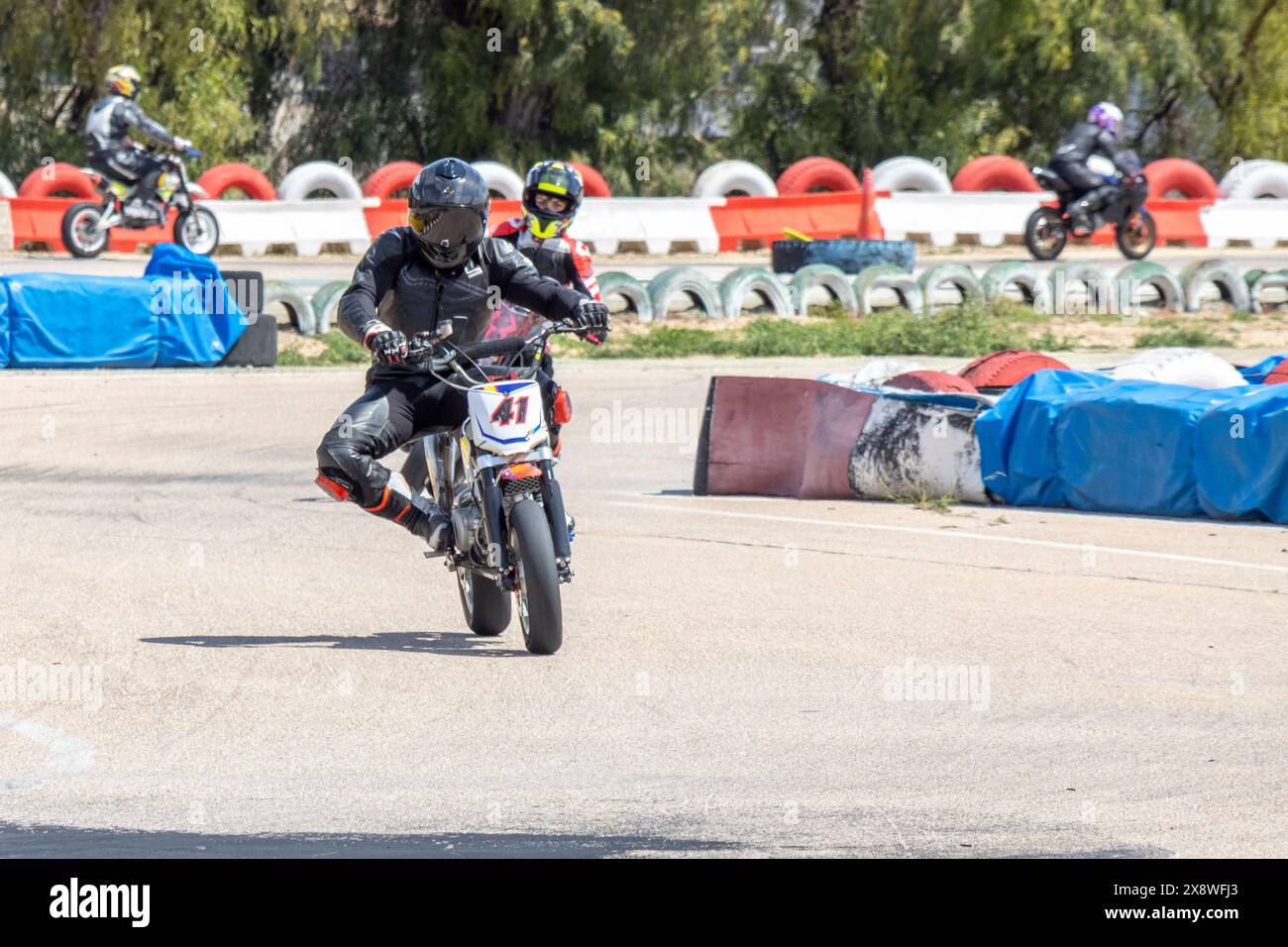 I motociclisti in marcia completa gareggiano su una pista, concentrandosi su velocità e controllo. Foto Stock