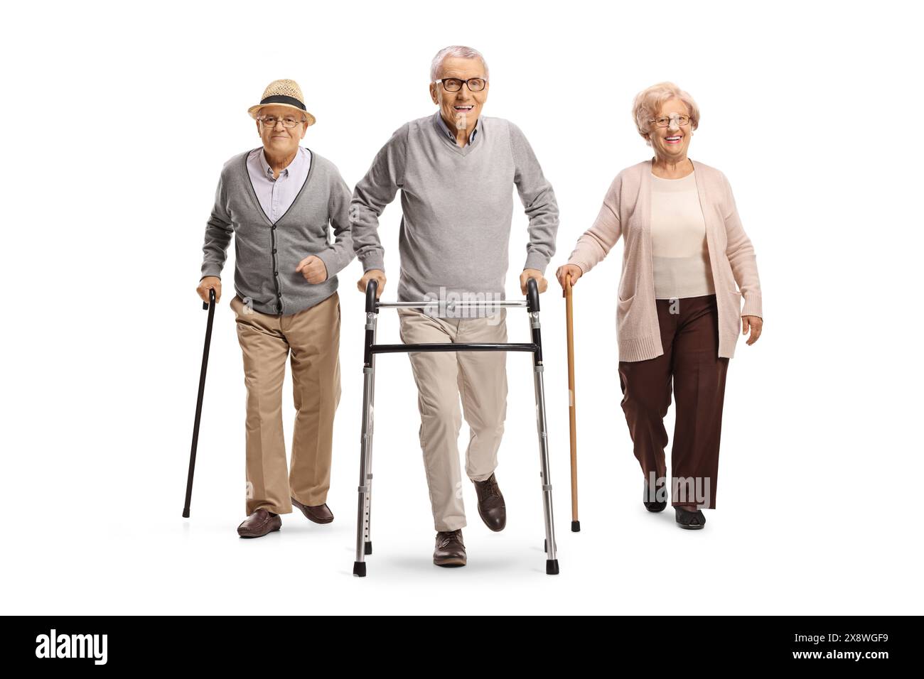 Uomini anziani e una donna che camminano con un camminatore e canne isolate su sfondo bianco Foto Stock