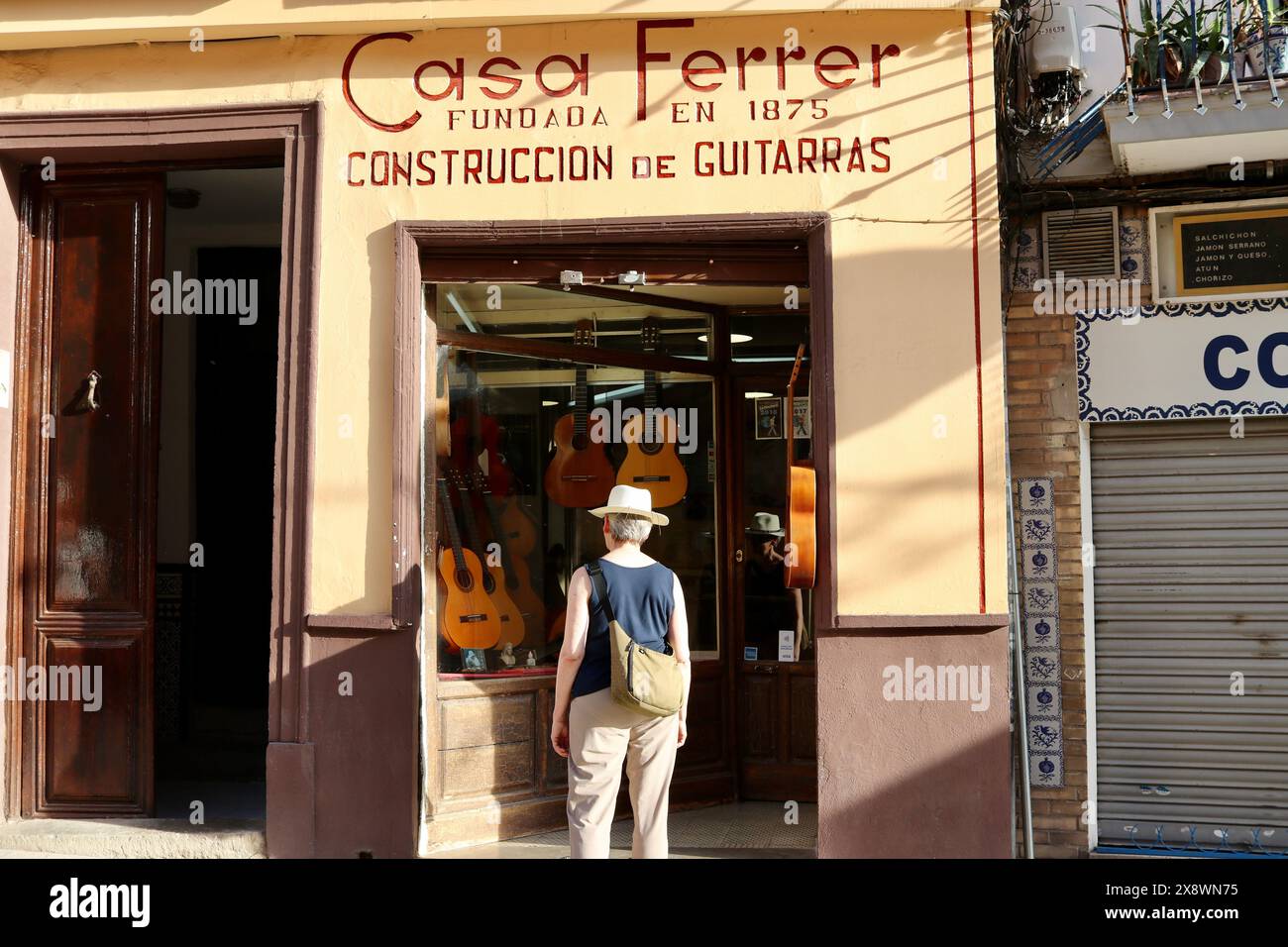 Un cliente che guarda le nuove chitarre in vendita presso Casa Ferrer, produttore di chitarre acustiche classiche, Granada, Spagna Foto Stock