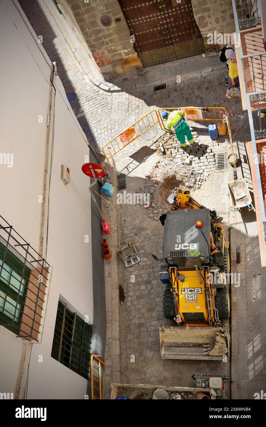 I lavoratori riparano i danni alle strade acciottolate di Siviglia, Spagna Foto Stock