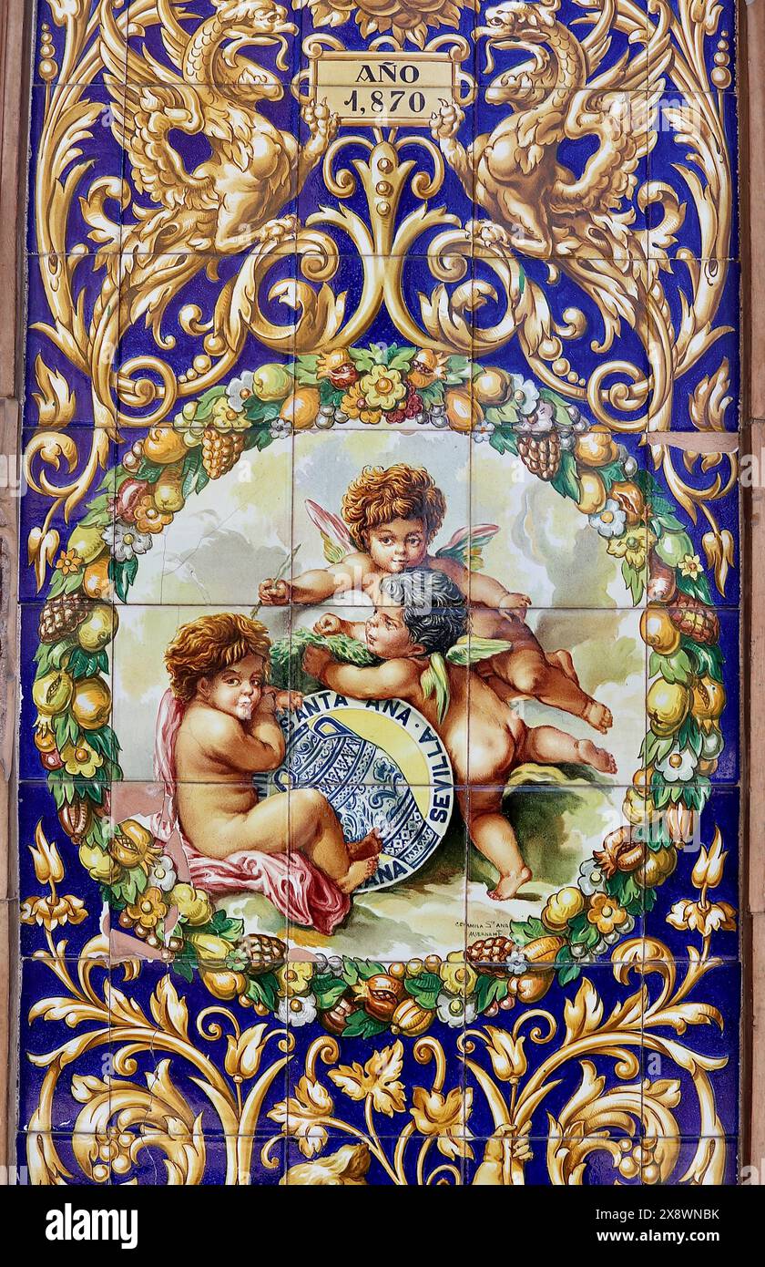 Piastrelle ornate dipinte, o azulejos, che mostrano i cherubini che si godono la loro visita a Siviglia, in Spagna Foto Stock