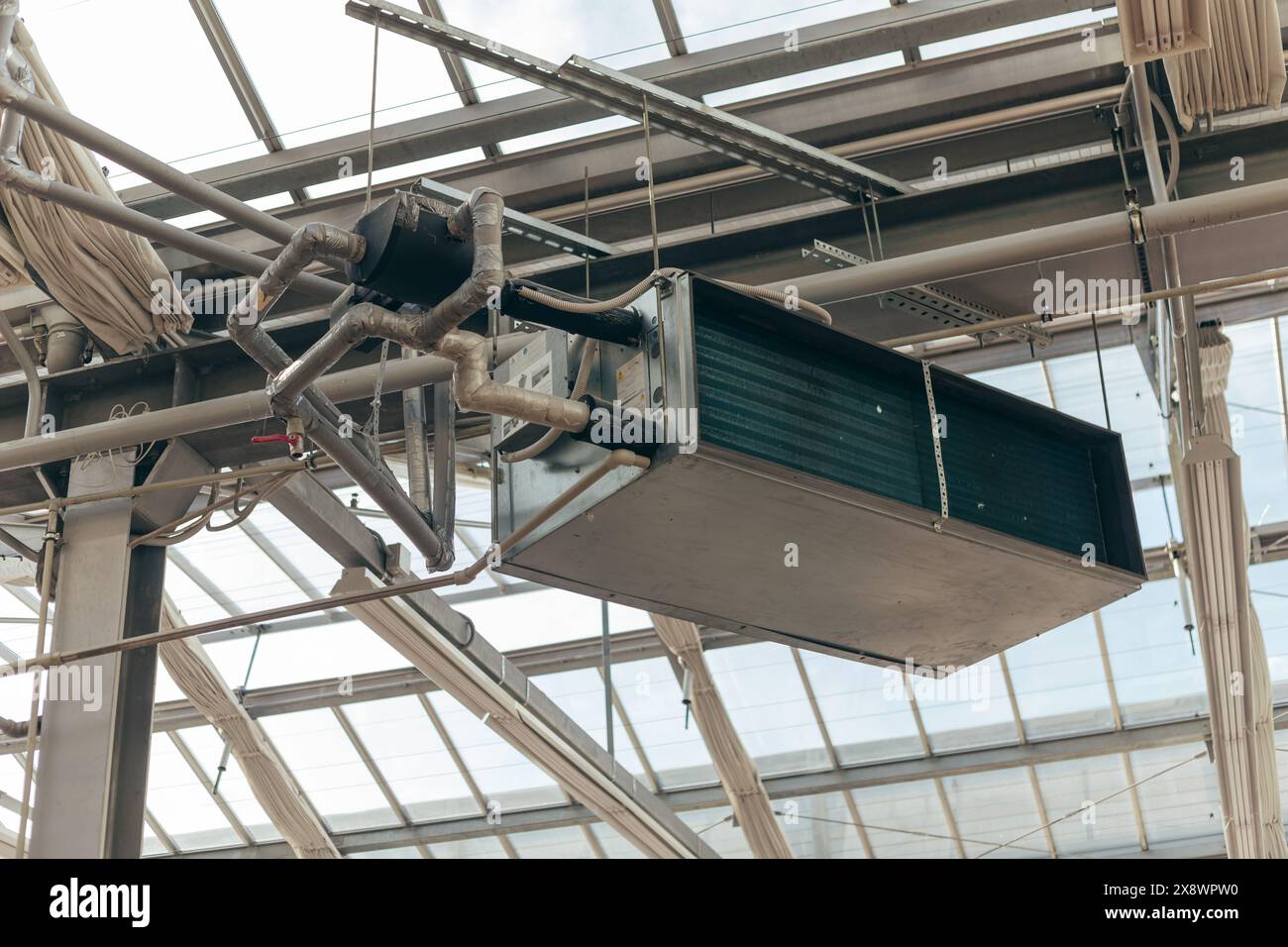 Unità di trattamento aria condizionata industriale sospesa sulla struttura del telaio sotto il soffitto Foto Stock