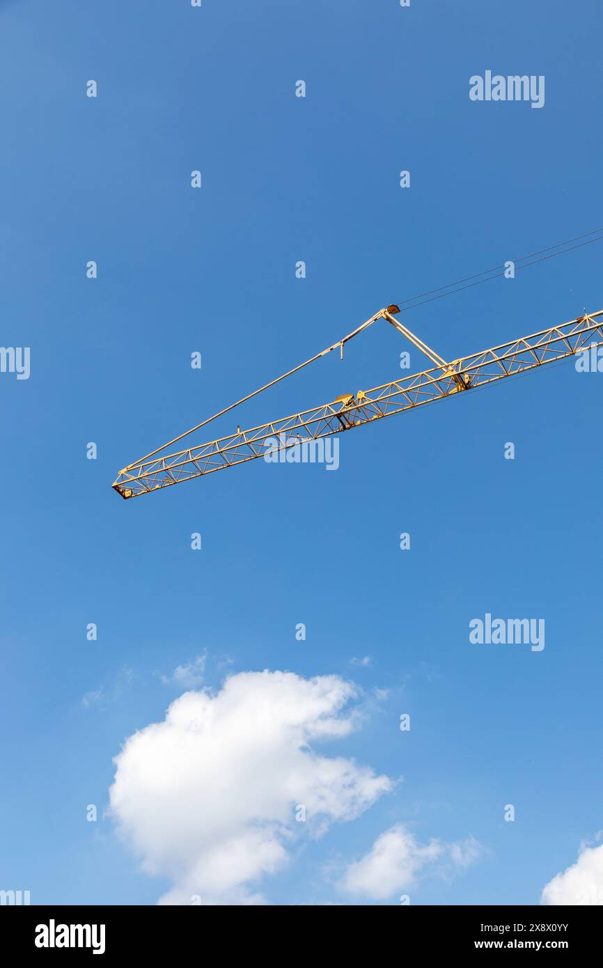 vista della grande gru sotto il cielo azzurro come simbolo del cantiere Foto Stock