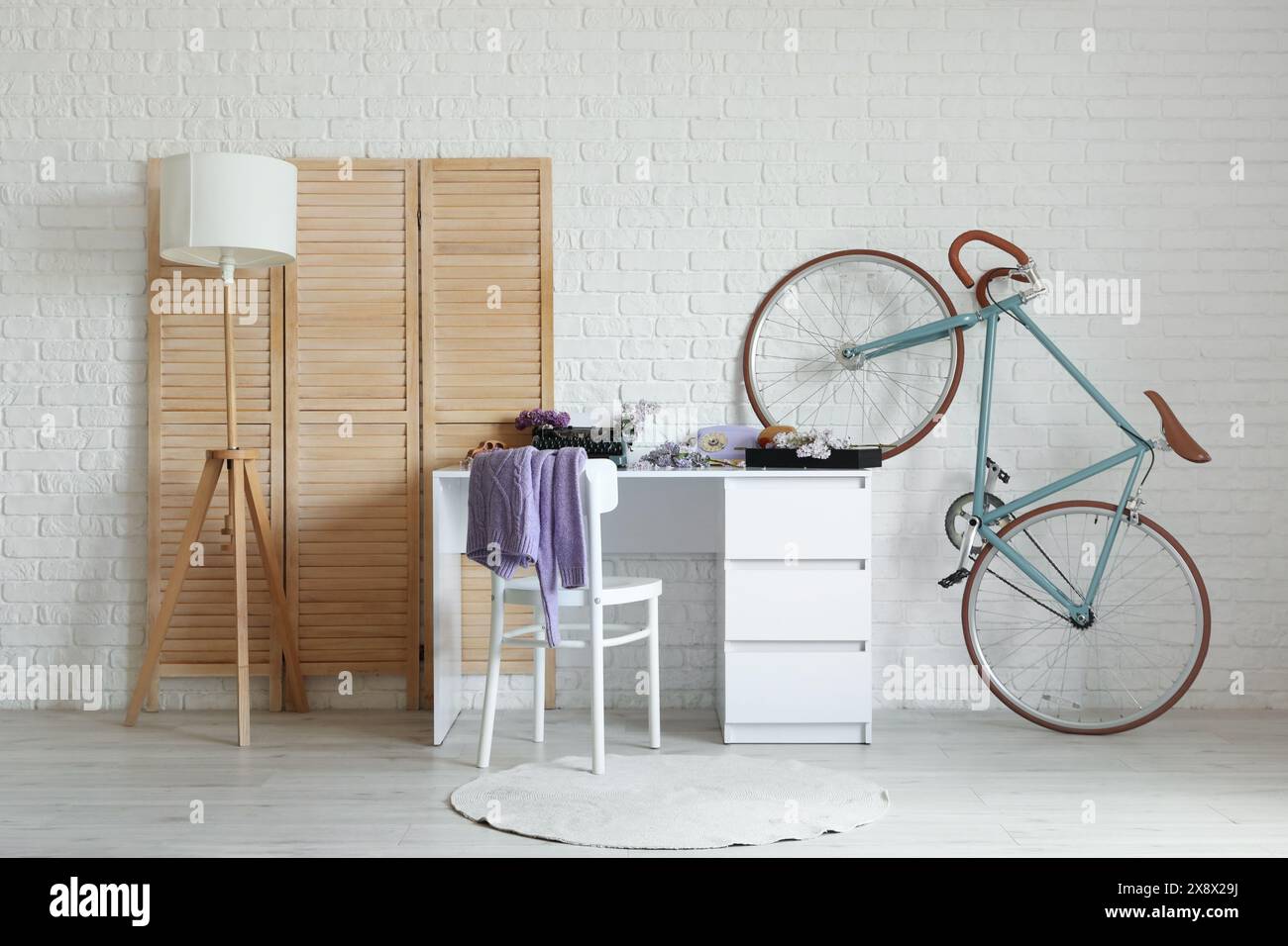 Interno dell'ufficio dell'autore con fiori lilla e macchina da scrivere vintage sul tavolo Foto Stock