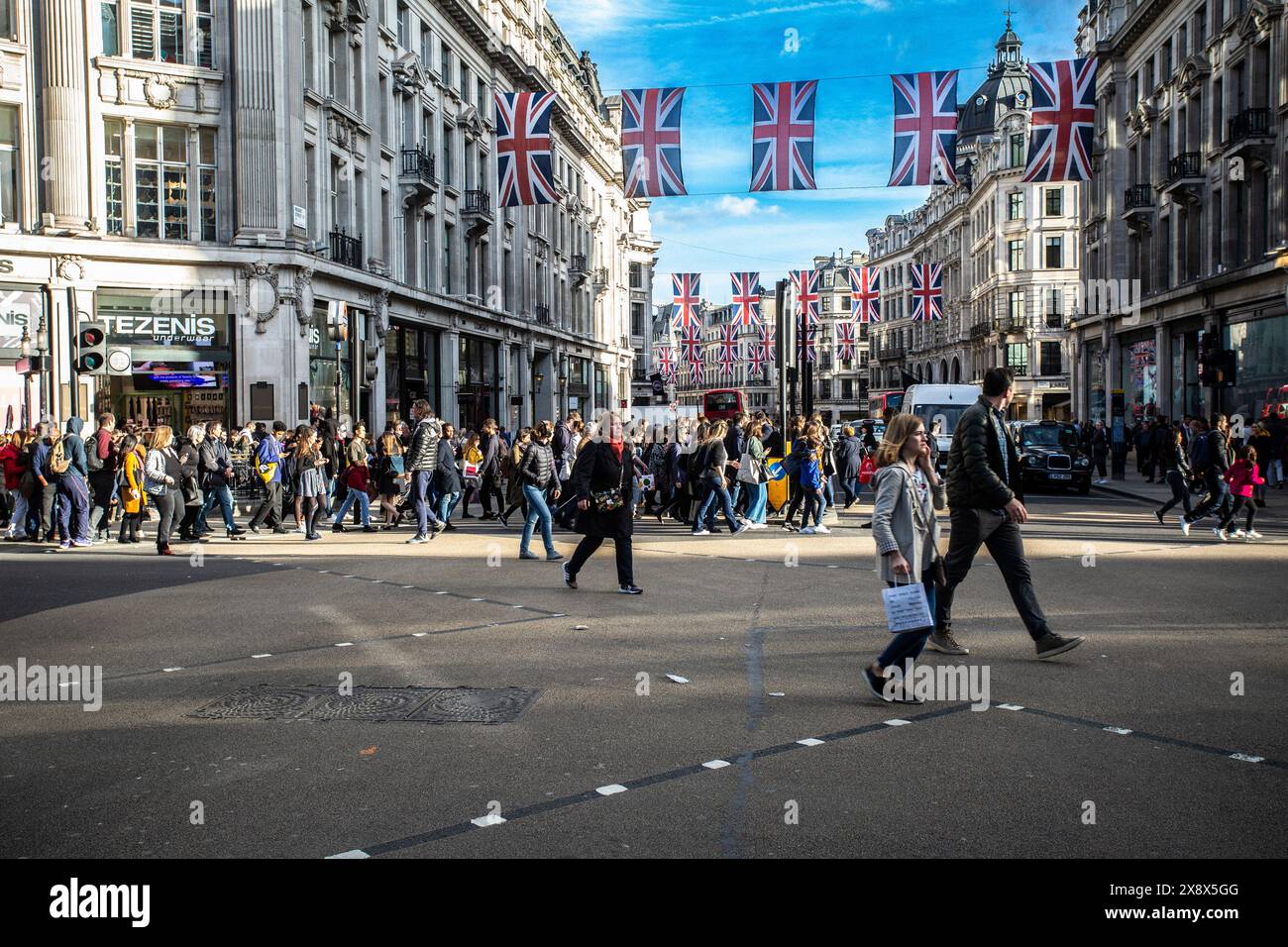 I pedoni di Regent Street all'incrocio diagonale di Oxford Circus, Londra, Regno Unito Foto Stock