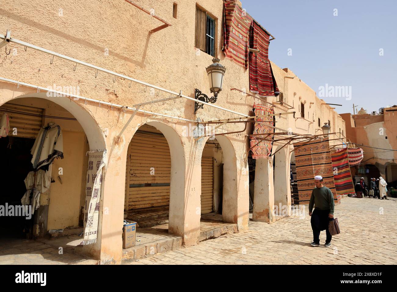 Tappeti appesi all'esterno di abitazioni tradizionali in vendita nella piazza principale di Ghardaial. Valle di Mzab. Provincia di Ghardaia. Sahara settentrionale. Algeria Foto Stock