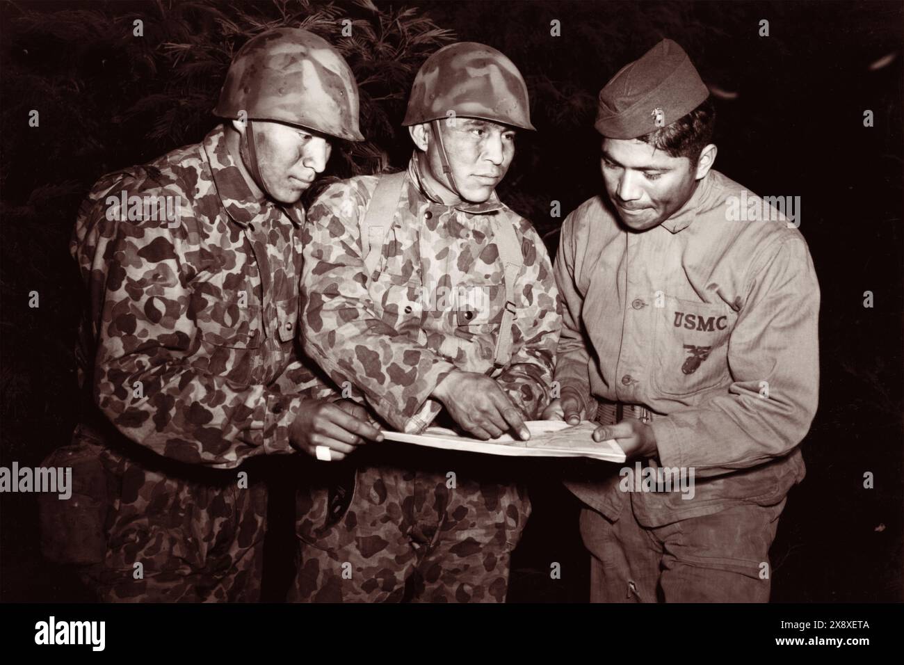 I code talker Navajo, membri della compagnia di segnalazione e associati alla 1st Marine Division nel sud-ovest del Pacifico, studiano un problema notturno presso la Amphibious Scout School condotto dalla sezione Intelligence durante la seconda guerra mondiale nel 1943. Foto Stock