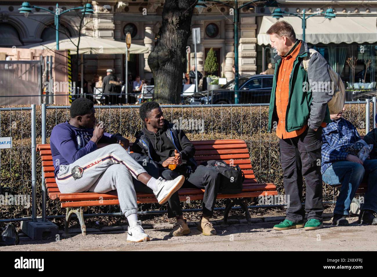 Uomini che hanno una conversazione la vigilia di maggio nell'Esplanade Park di Helsinki, Finlandia Foto Stock