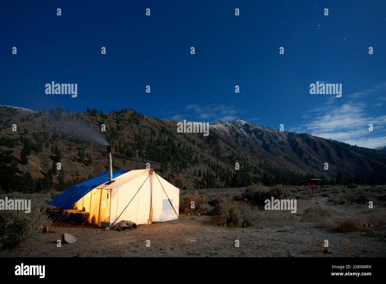 Tenda calda nel campo di caccia illuminata sotto il cielo stellato della notte, Thomas Creek, Frank Church River of No Return Wilderness, Idaho, Stati Uniti Foto Stock