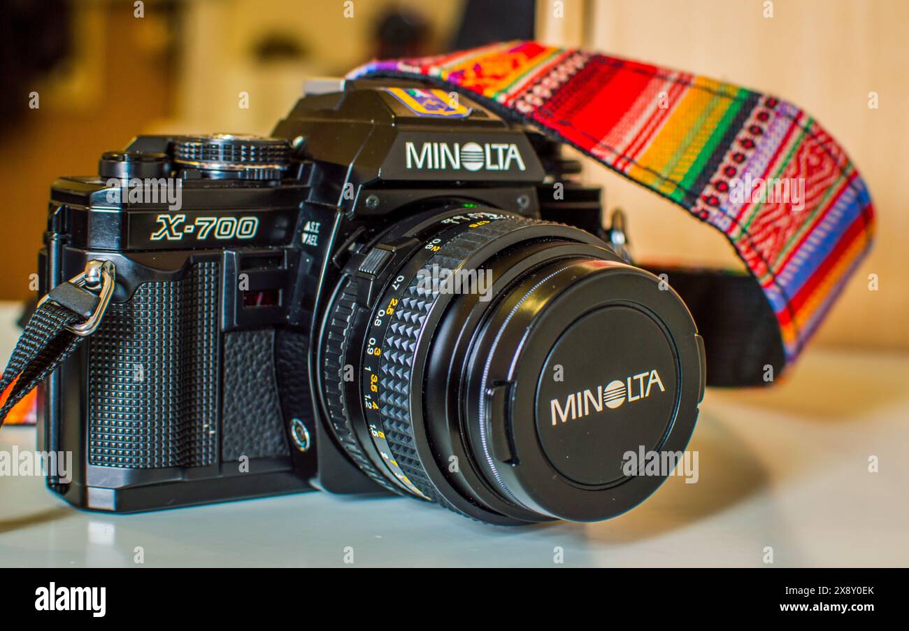 Primo piano di una classica fotocamera Minolta X-700 con cinturino colorato. Ideale per gli appassionati di fotocamere d'epoca, gli amanti della fotografia cinematografica e i collezionisti. Foto Stock