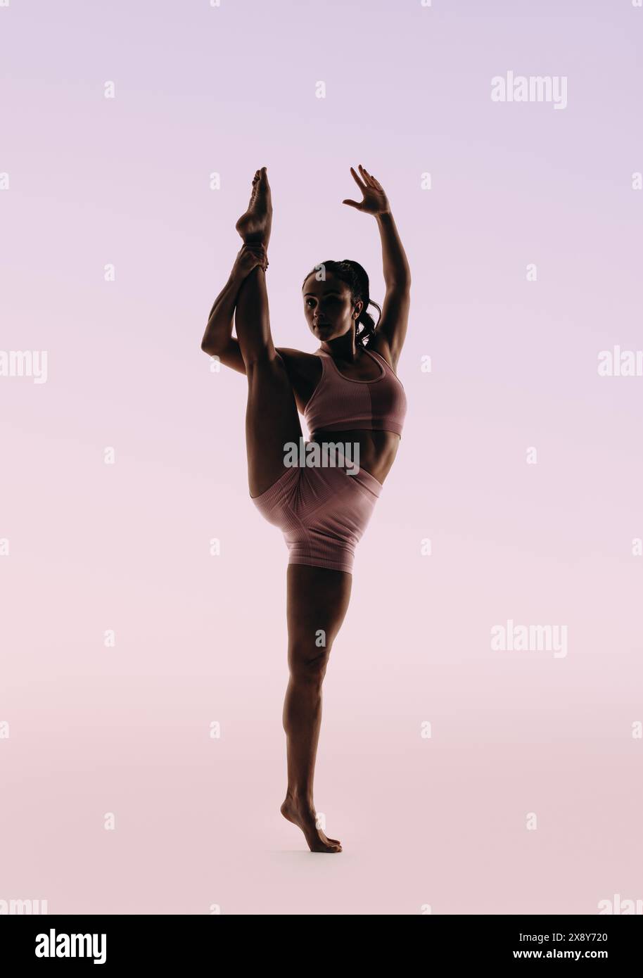 La ballerina Fit mette in mostra la sua abilità e flessibilità in una classica routine di danza. Con un equilibrio perfetto e un fisico magro, si mette in posa una gamba sola, di Foto Stock