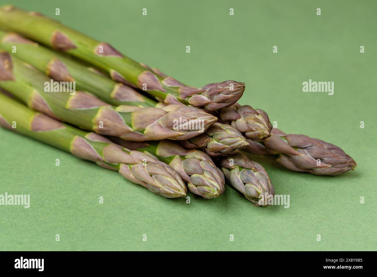 Punte di asparagi verdi su sfondo verde Foto Stock