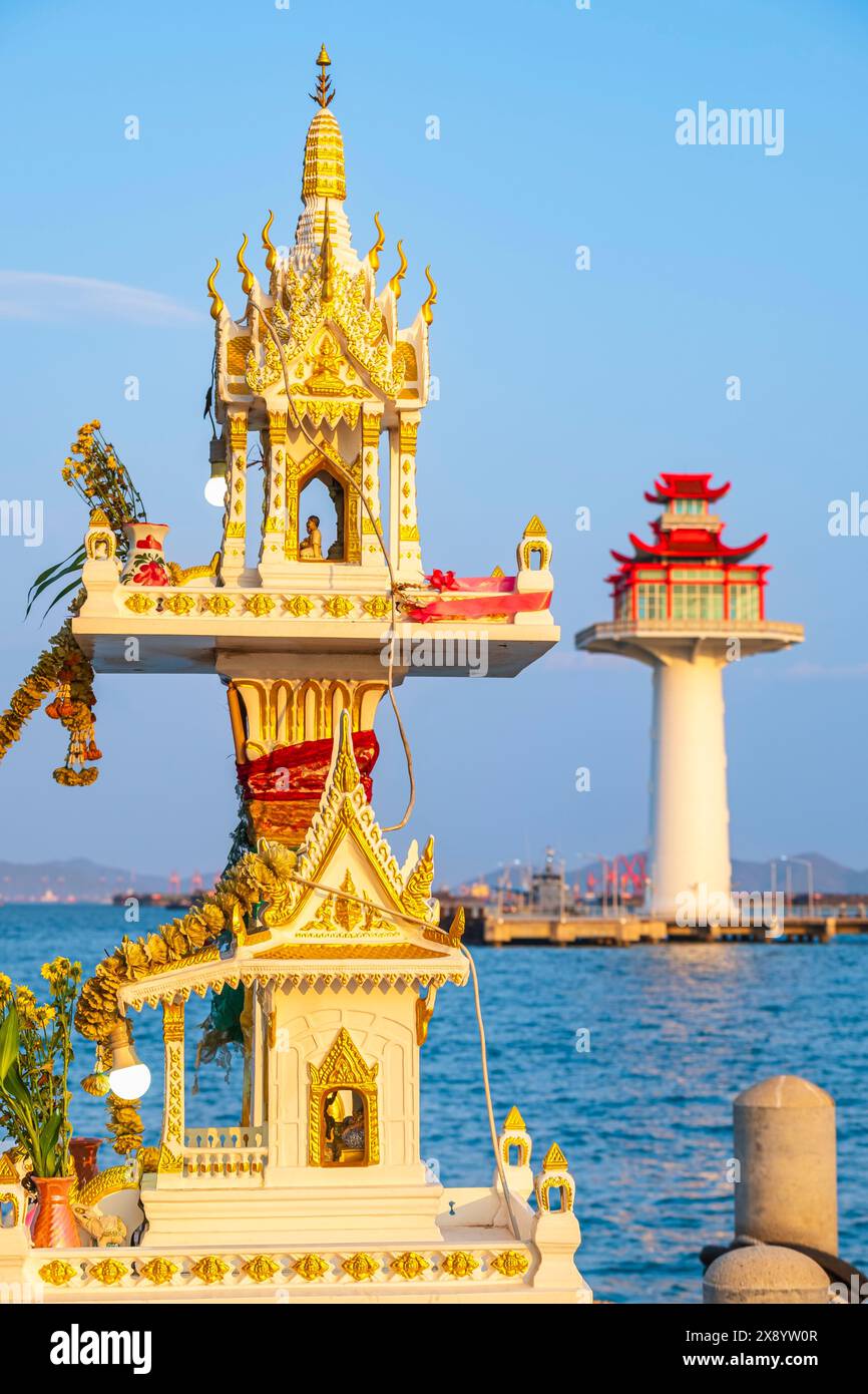 Thailandia, provincia di Chonburi, isola di Ko Sichang, oratorio buddista nel porto, faro cinese a forma di pagoda sullo sfondo Foto Stock