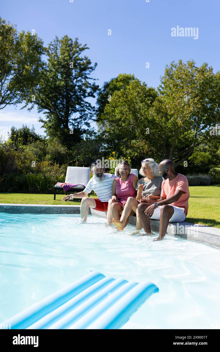 All'aperto, diversi amici anziani che ridono in piscina e condividono battute Foto Stock
