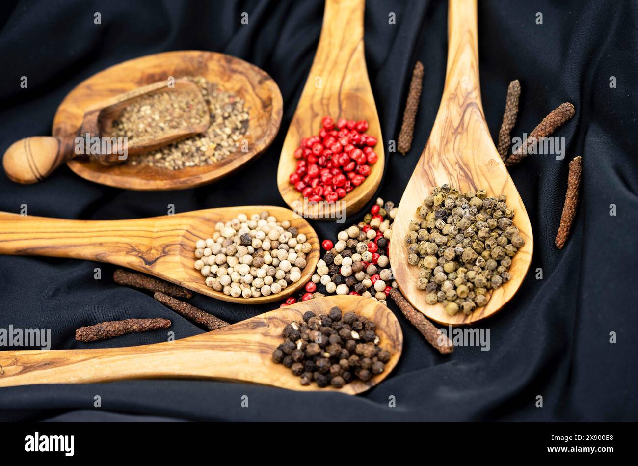 Pepe bianco, rosso, nero e verde su cucchiai di legno Foto Stock