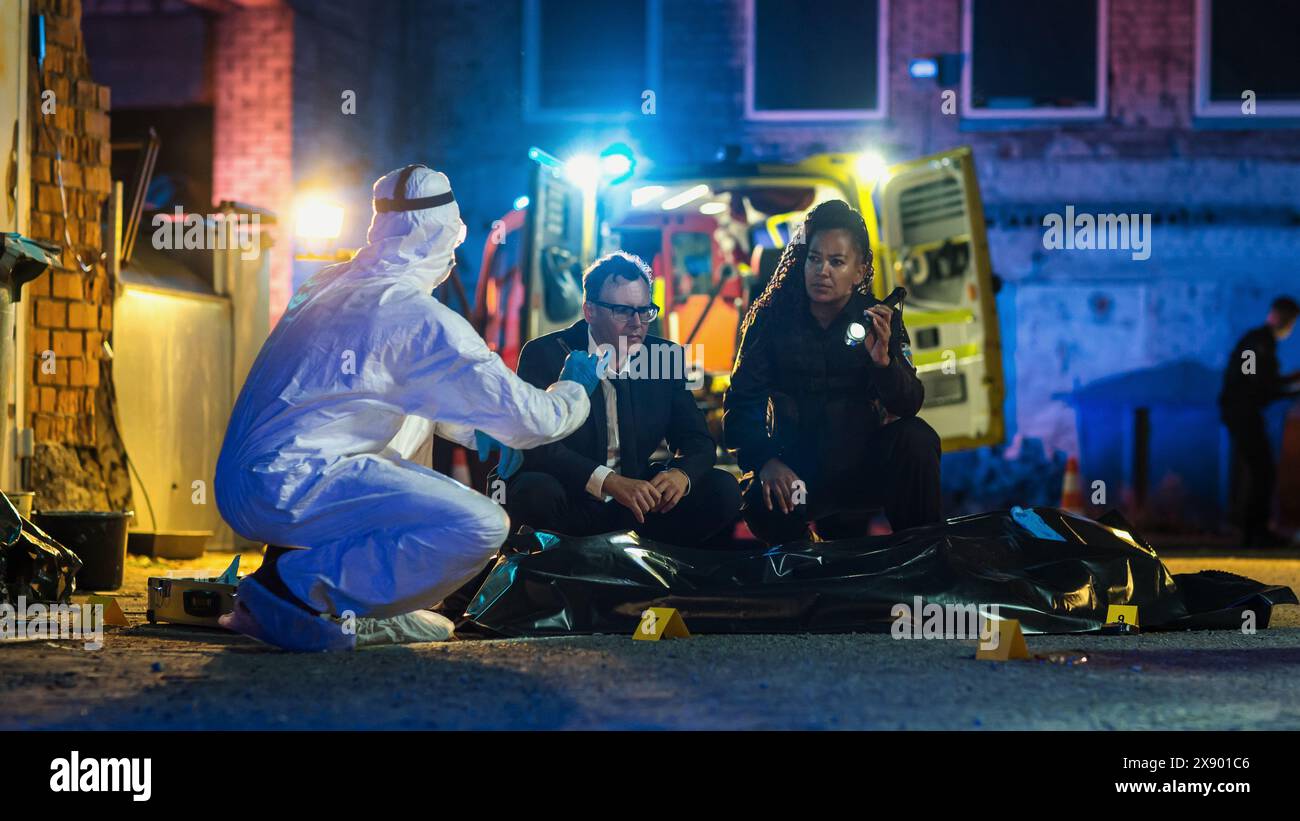 Polizia e Forensics collaborano per risolvere un recente caso di omicidio. Detective esperto intelligente che mette a confronto un proiettile trovato sulla scena del crimine con la potenziale arma del delitto. Vero crimine Foto Stock