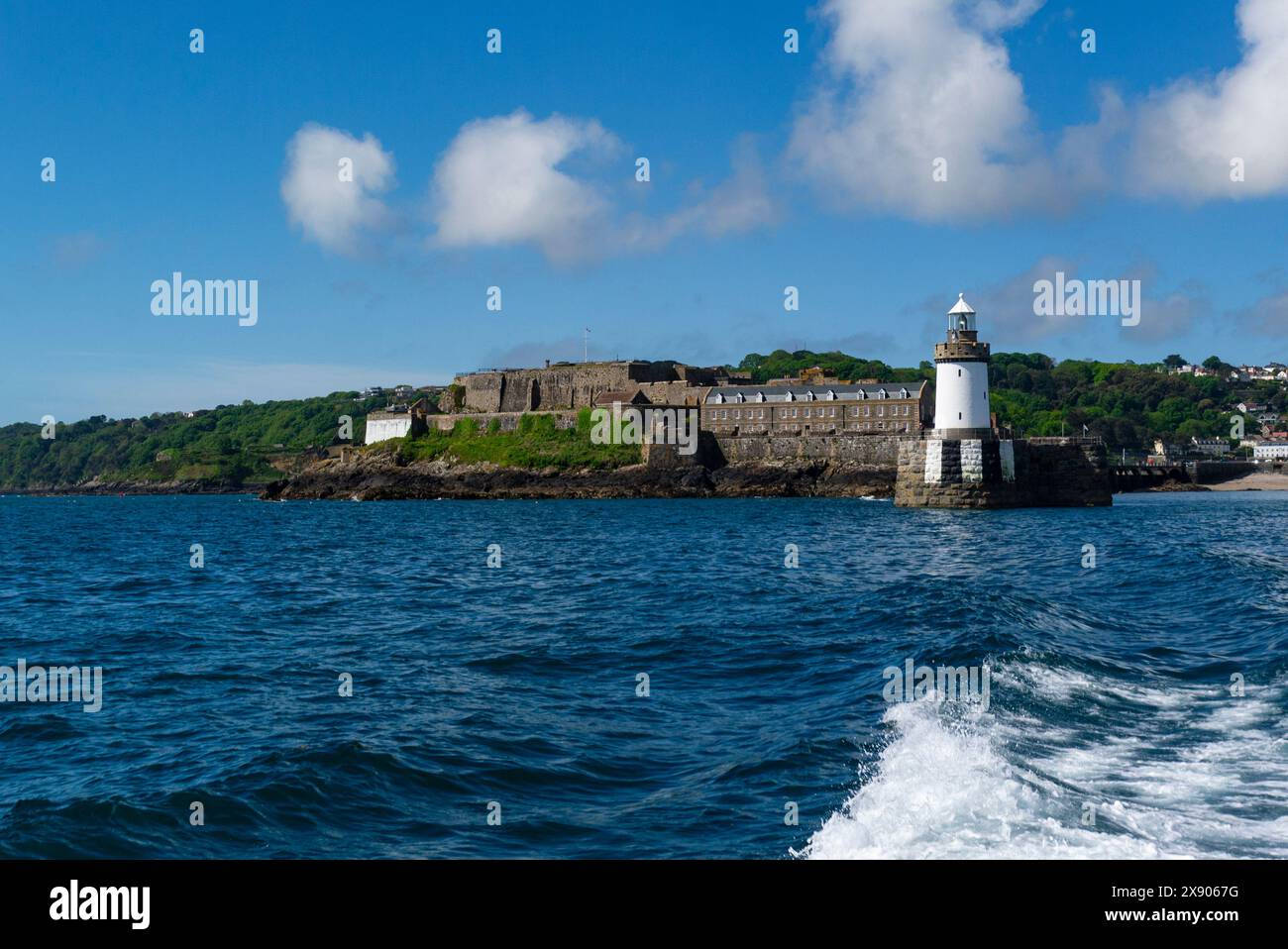 Castle Cornet e il faro alla fine del Castle Pier all'ingresso della capitale del porto di St Peter, Guernsey Channel Islands, un bel giorno di sole di maggio Foto Stock