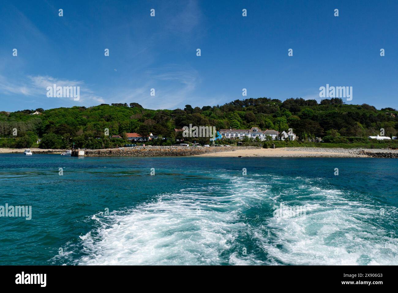 Traghetto che parte dal porto di Herm Island e fa ritorno ai passeggeri della gita di un giorno alle Isole del Canale di Guernsey in un incantevole giorno di maggio con cielo blu e mare Foto Stock