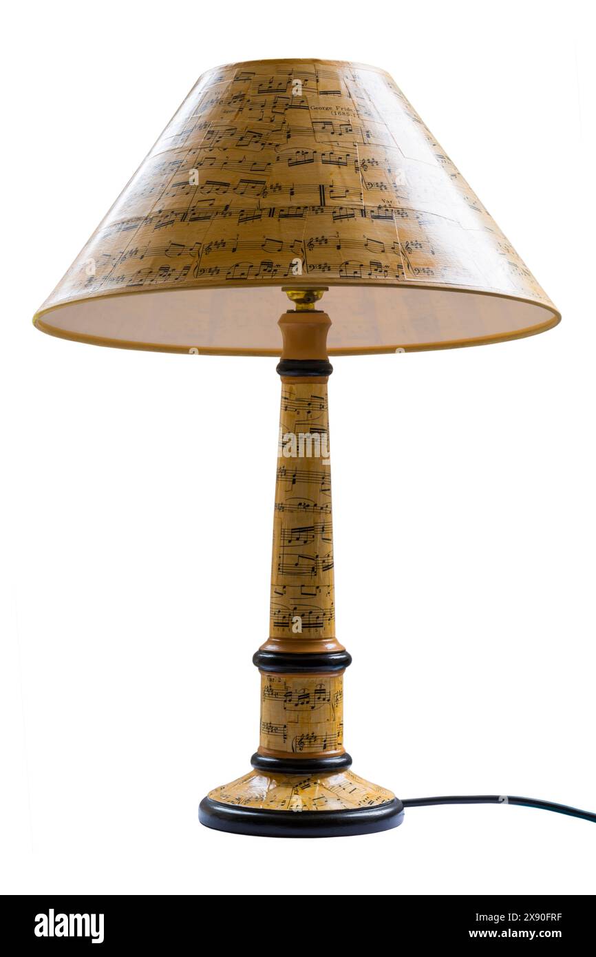 lampada a tema musicale con paralume decorato con spartiti su sfondo bianco Foto Stock