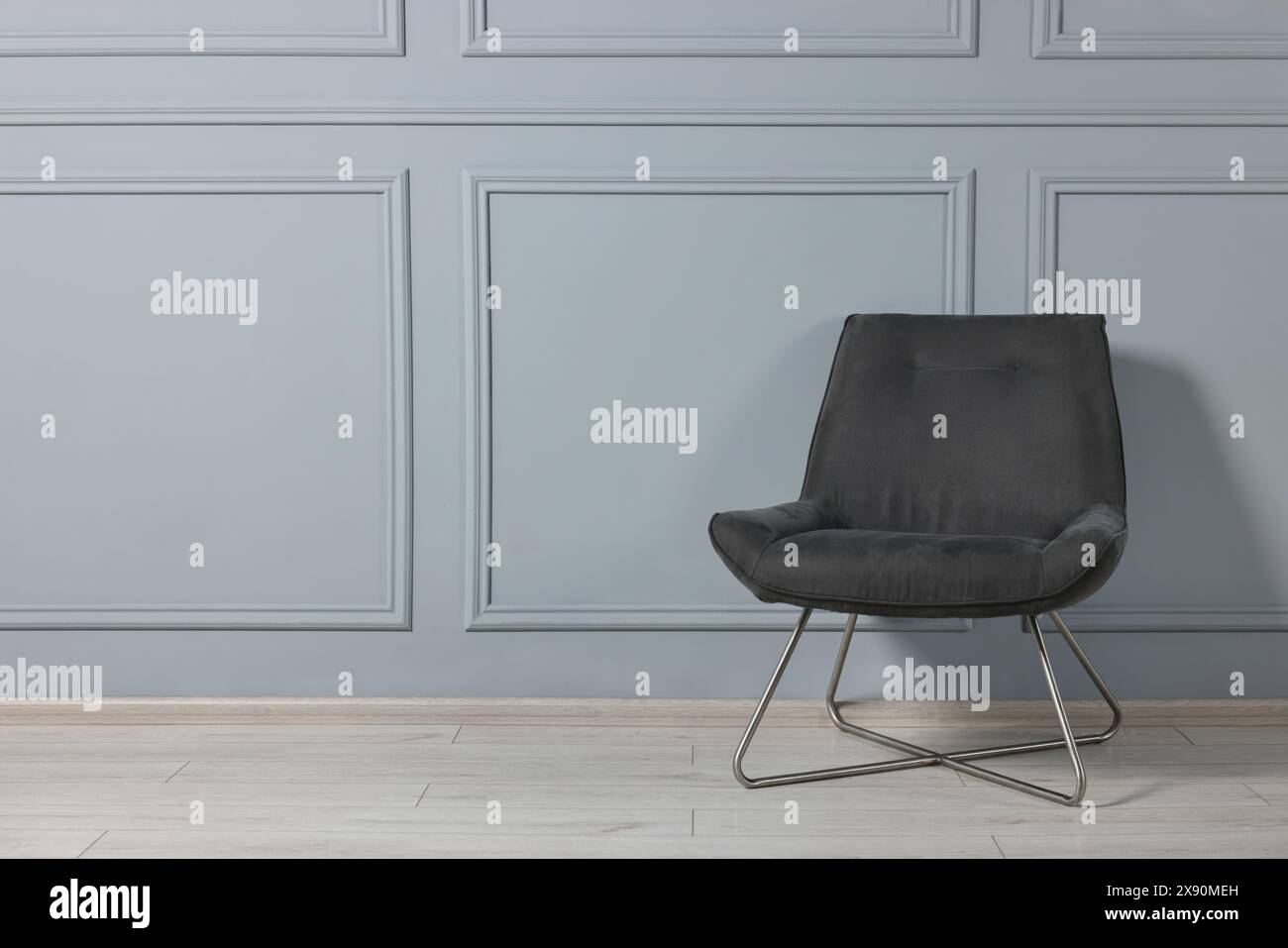 Comoda poltrona vicino alla parete grigia della stanza, spazio per il testo Foto Stock