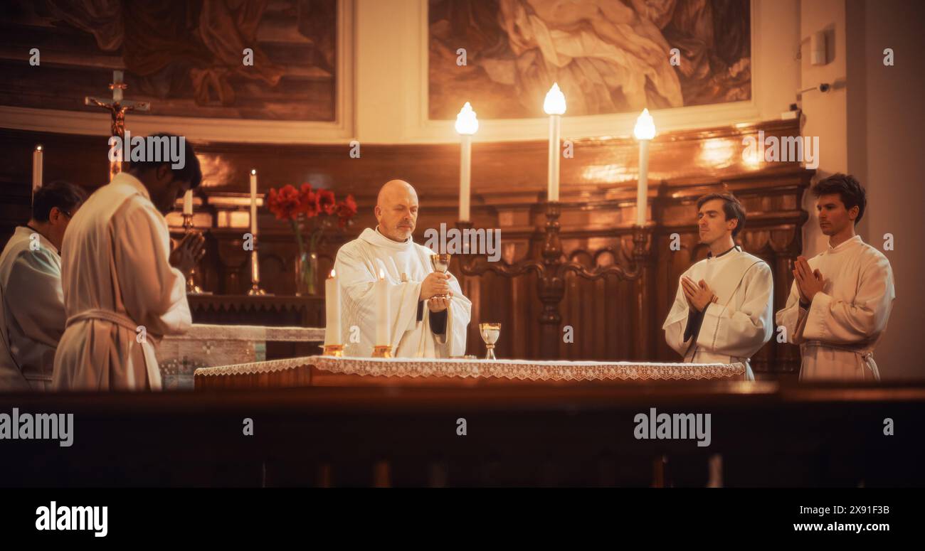 Il servizio Eucaristico nella grande Chiesa: I Ministri della fede cristiana guidano la cerimonia che prevede la condivisione del pane in onore di Gesù Cristo. Santa Comunione, Santa messa Divina, cena del Signore sull'altare Foto Stock