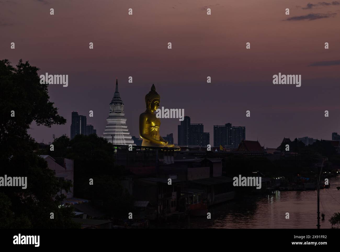Un'immagine della grande statua di Buddha al tempio Wat Paknam Bhasicharoen, vista da lontano, al tramonto. Foto Stock