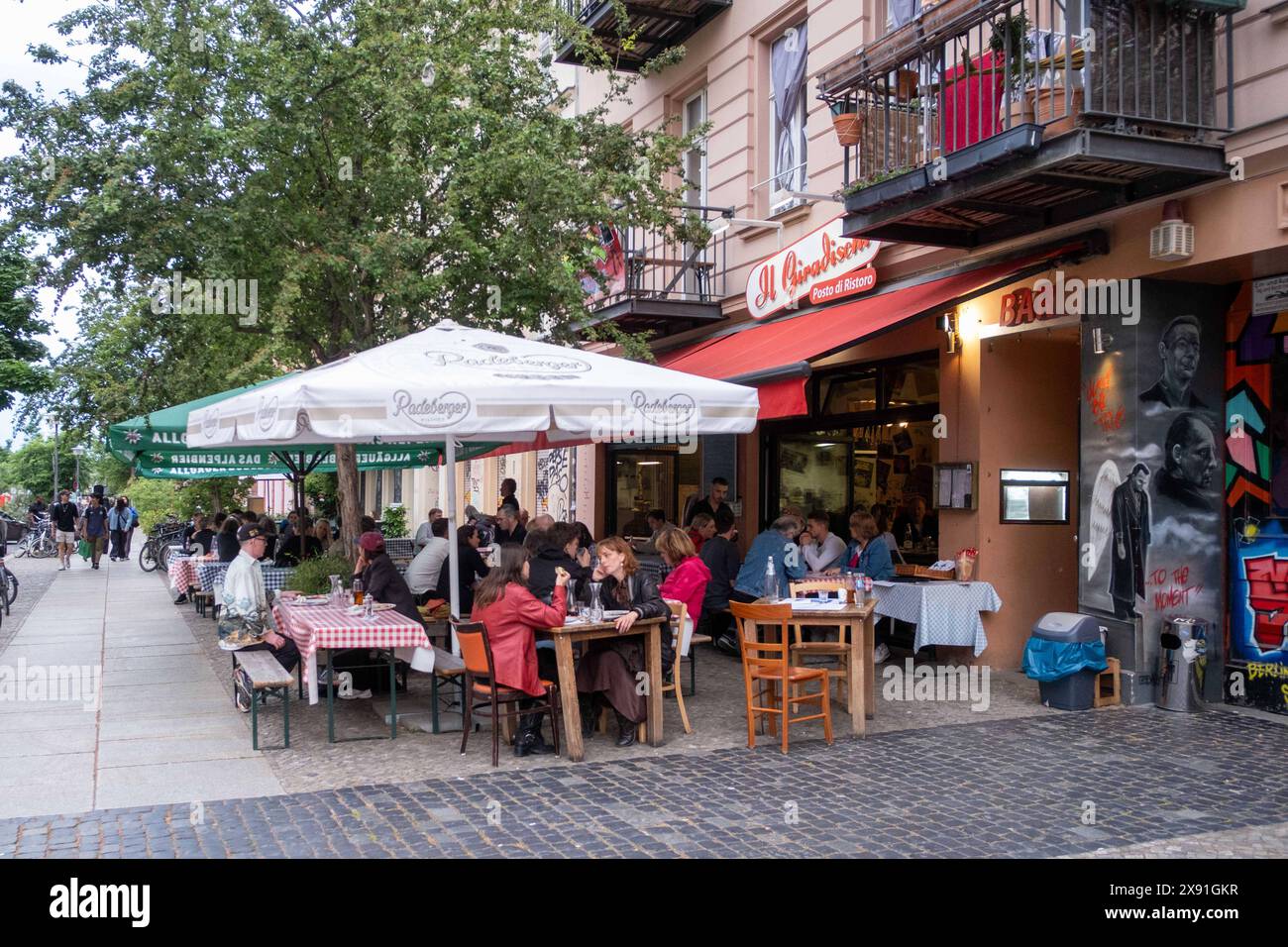 Freisitz eines italienischen ristoranti in der Oderberger Straße a Berlino-Prenzlauer Berg. / Area salotto all'aperto di un ristorante italiano in Oderberger Strasse a Berlino-Prenzlauer Berg. Ristorante *** area esterna con posti a sedere di un ristorante Italiano in Oderberger Strasse a Berlino Prenzlauer Berg area esterna con posti a sedere di un ristorante Italiano in Oderberger Strasse a Berlino Prenzlauer Berg Restaurant snph202405245263.jpg Foto Stock