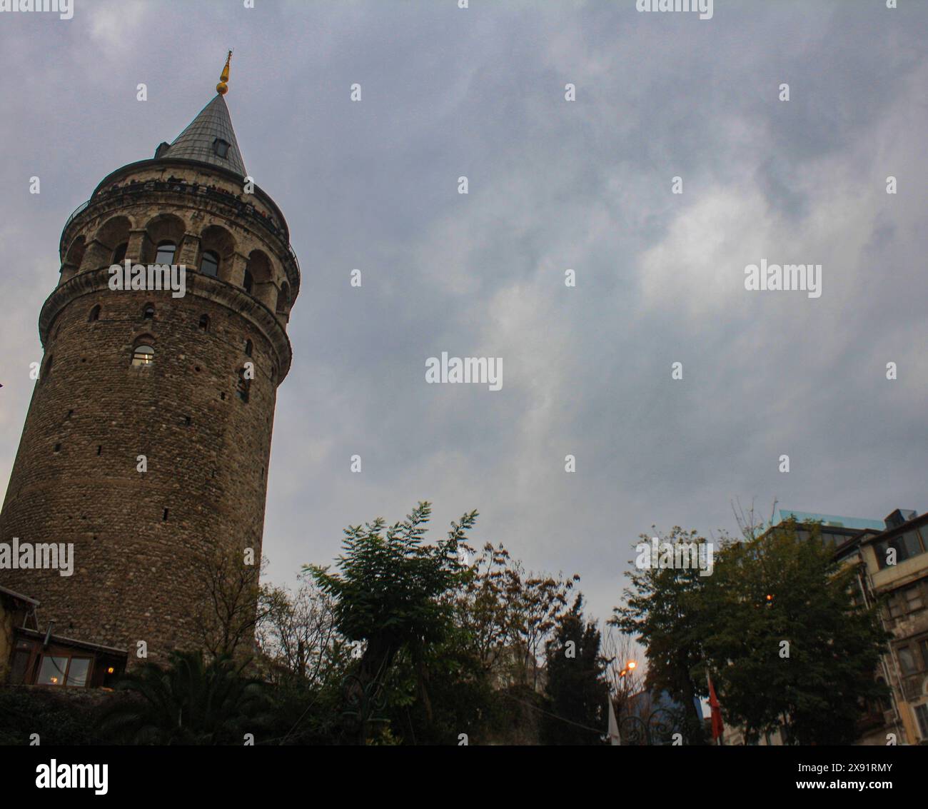 Una vista accattivante della storica Torre Galata di Istanbul, adagiata contro un cielo nuvoloso. Questa antica struttura, con il suo caratteristico tetto conico, stan Foto Stock