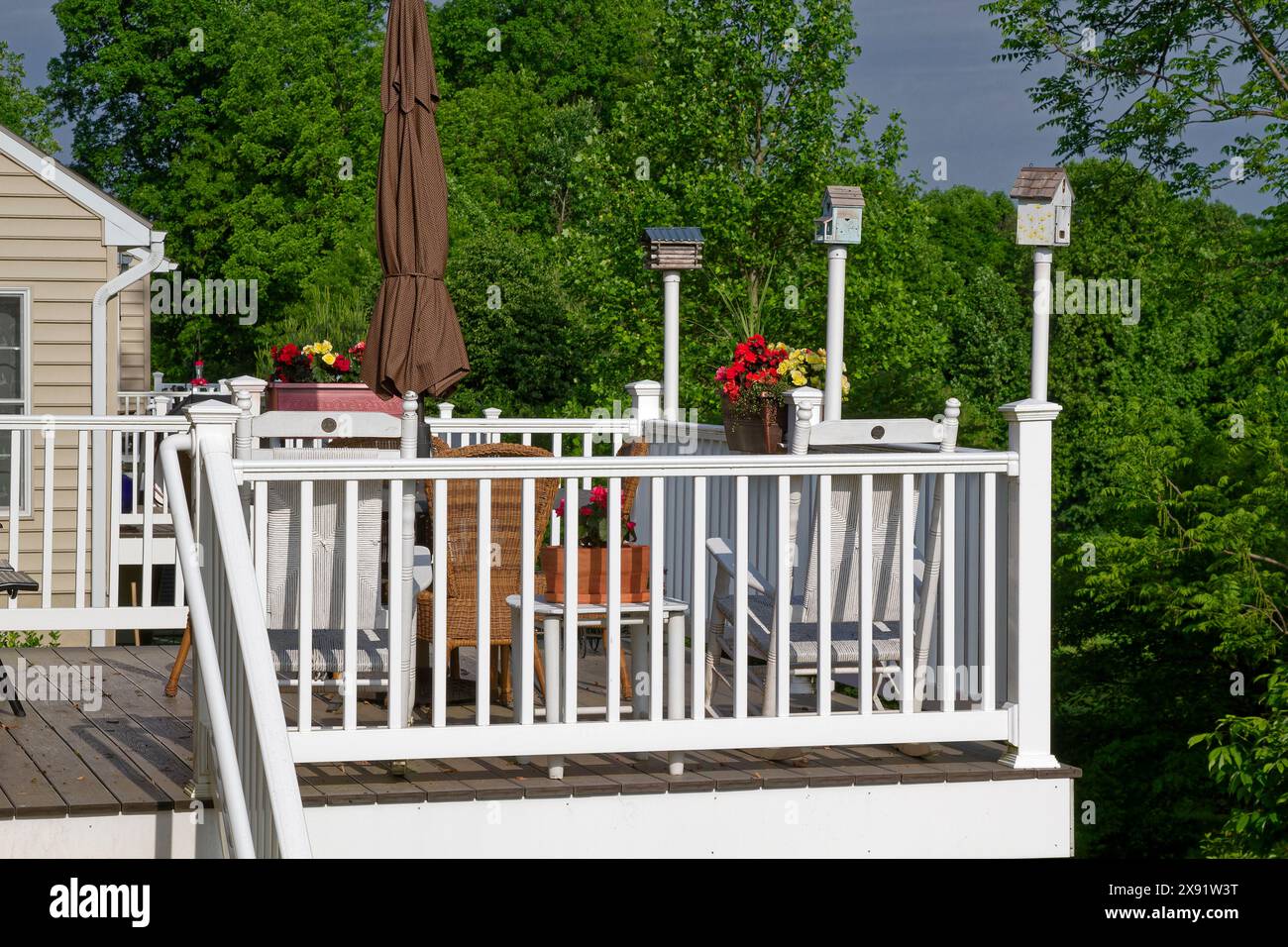 ponte, 3 casette per uccelli, ombrello chiuso, sedie, fiori in vaso, attraente, bello, grazioso, alberi oltre, posto per rilassarsi, Summer, Pennsylvania, PR Foto Stock