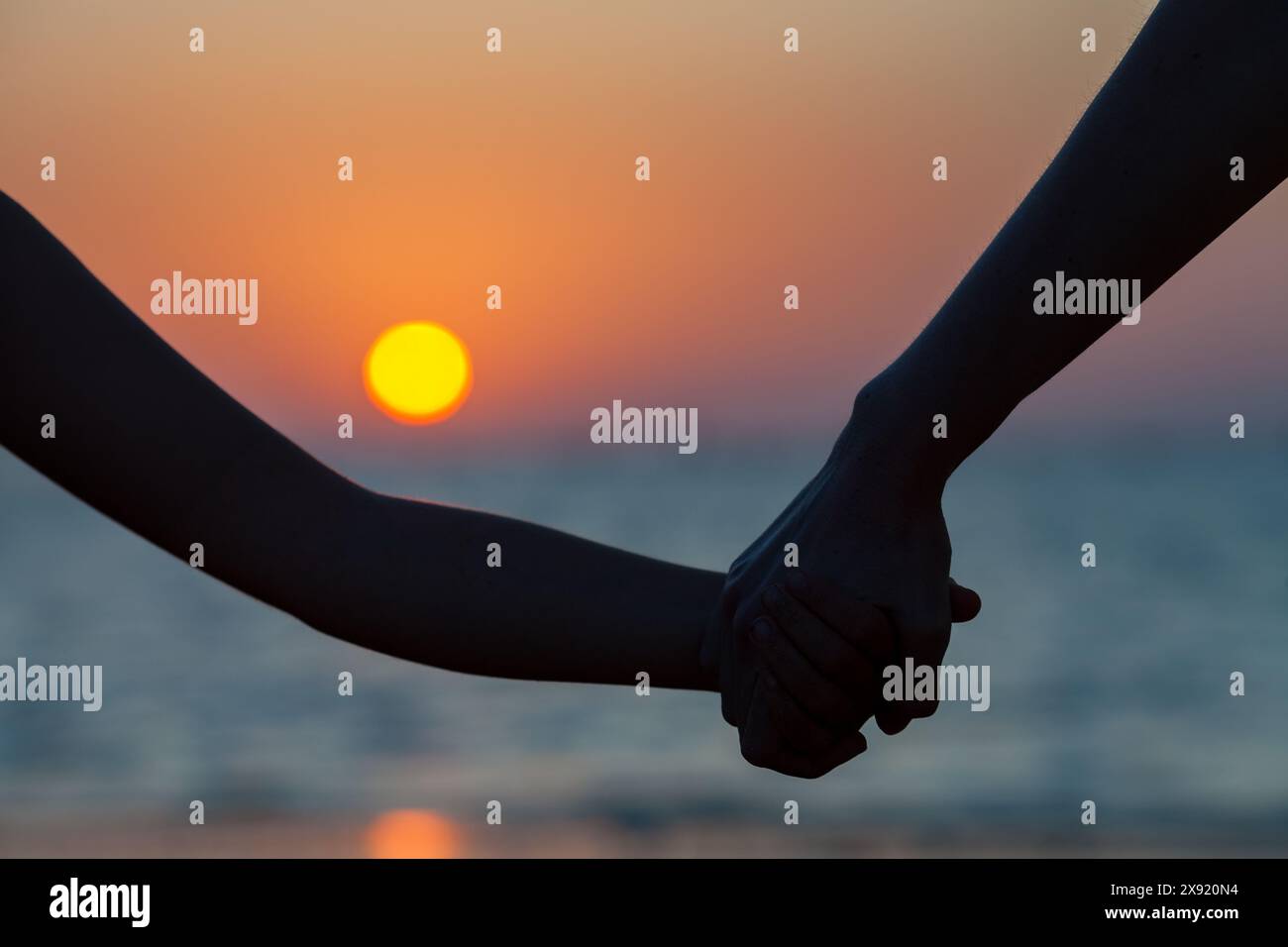 Una madre e sua figlia si tengono per mano mentre si godono un tramonto a Sanlucar de Barrameda Beach, Cadice, Spagna. Foto Stock