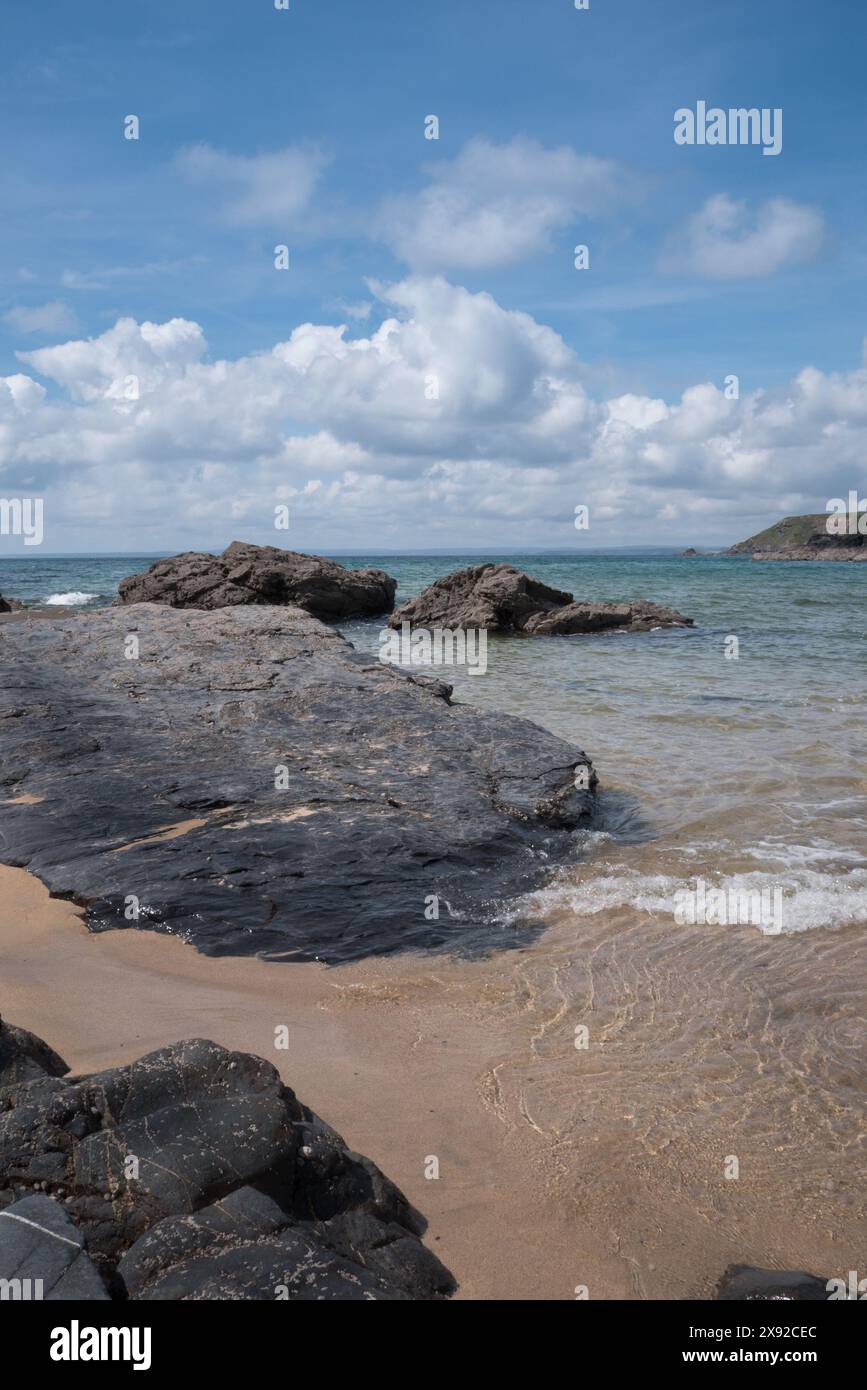 Mare calmo a Poldhu Cove sulla penisola di Lizard, Cornovaglia, Regno Unito. Conosciuta anche come Black Cove (Poldhu). Con il mare aperto, una famosa spiaggia per il surf e una baia. Foto Stock