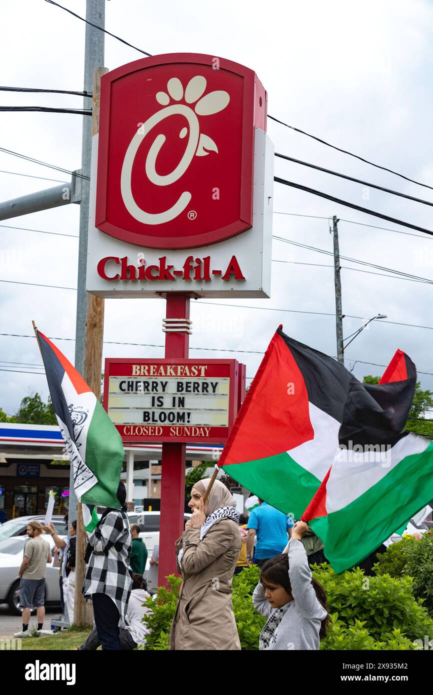 Toledo, Ohio, Stati Uniti. 27 maggio 2024. I manifestanti pro-palestinesi sventolano le bandiere palestinesi mentre marciano davanti a un cartello di Chick-fil-A durante una Toledo, il tutto per la dimostrazione di Rafah. Il capitolo dei musulmani americani per la Palestina di Toledo ha organizzato la protesta come una "protesta d'emergenza” in reazione agli attacchi aerei israeliani che hanno colpito gli sfollati nelle tende nella città di Rafah a sud di Gaza. (Credit Image: © Stephen Zenner/SOPA Images via ZUMA Press Wire) SOLO PER USO EDITORIALE! Non per USO commerciale! Foto Stock