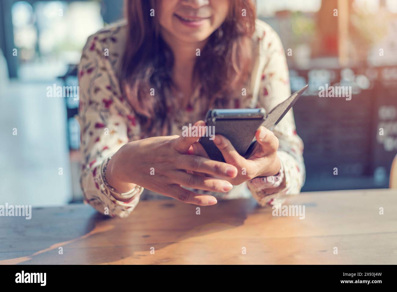 Donna asiatica che utilizza smartphone shopping sito web online su smartphone con il viso sorridente. Felicità donna asiatica che tiene il cellulare che controlla la posta dall'onlin Foto Stock