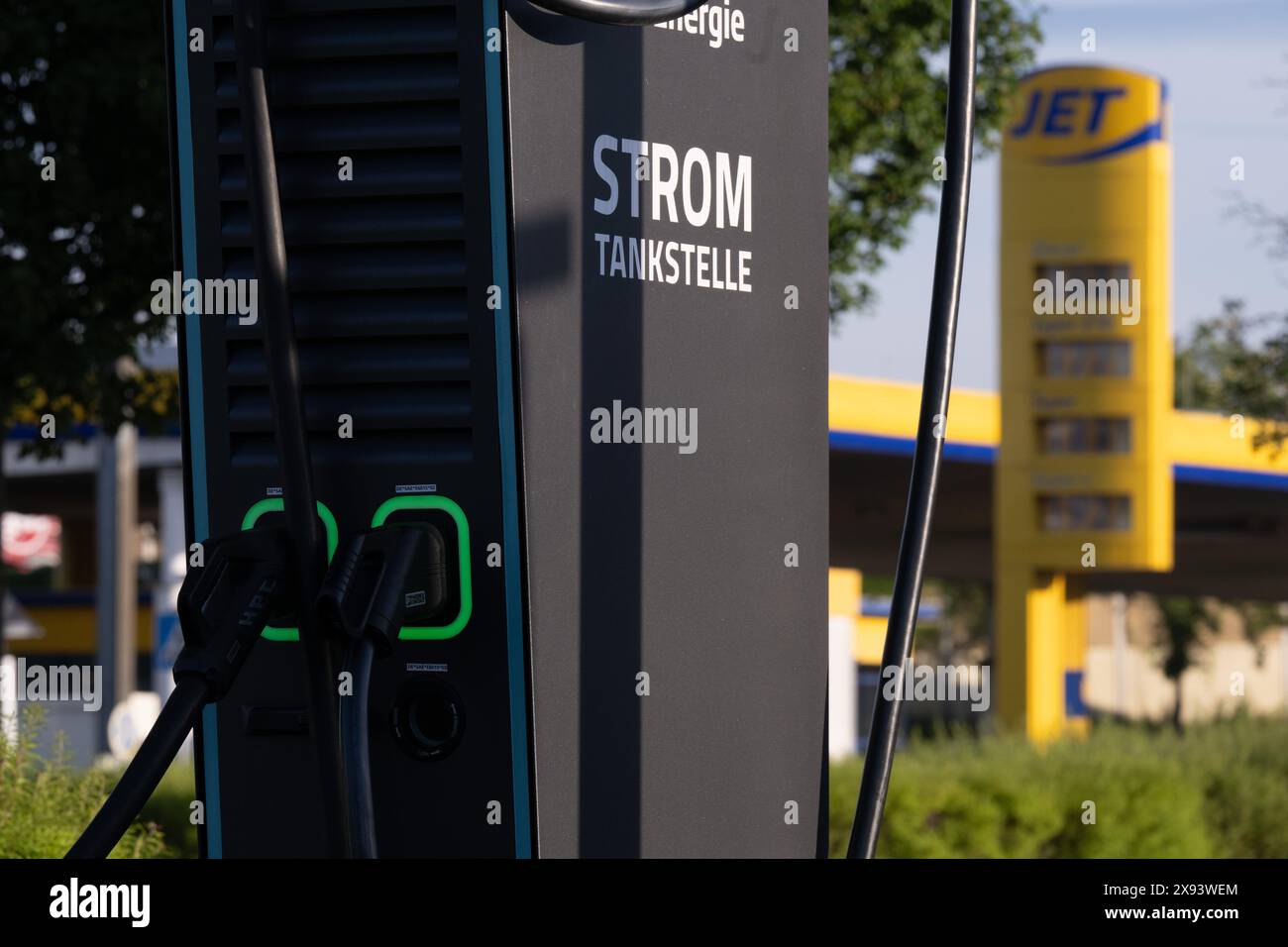 Dresda, Germania. 29 maggio 2024. Ugello del carburante presso una stazione di ricarica per auto elettriche di fronte a una stazione di rifornimento. In futuro, i conducenti di auto elettriche dovranno disporre di stazioni di ricarica più veloci nelle stazioni di rifornimento. Secondo i piani del governo tedesco, le grandi catene di stazioni di servizio in Germania saranno obbligate a costruire stazioni di ricarica rapida in futuro. Il Gabinetto federale intende avviare un corrispondente emendamento alla legge mercoledì. Crediti: Sebastian Kahnert/dpa/Alamy Live News Foto Stock