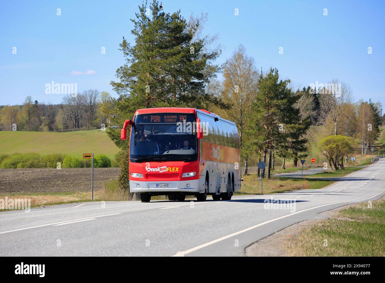 Pullman Red OnniBus FLEX dell'operatore di trasporto passeggeri OnniBus Oy sull'autostrada 110 in una giornata di sole di primavera. Salo, Finlandia. 11 maggio 2024. Foto Stock