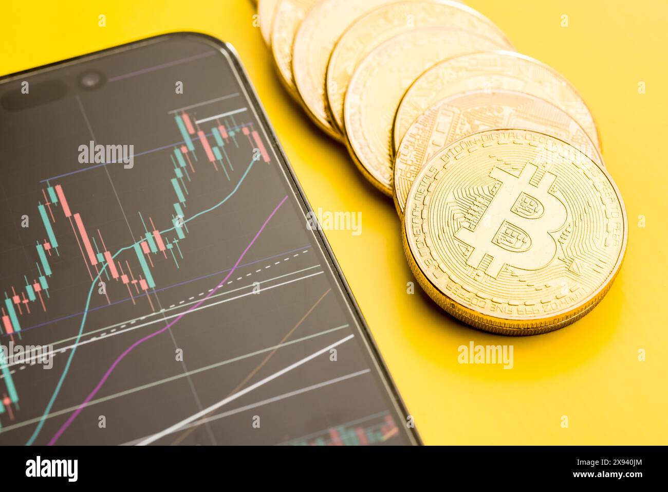 Moneta d'oro Bitcoin. Criptovaluta e grafico aziendale in un cellulare. Foto Stock