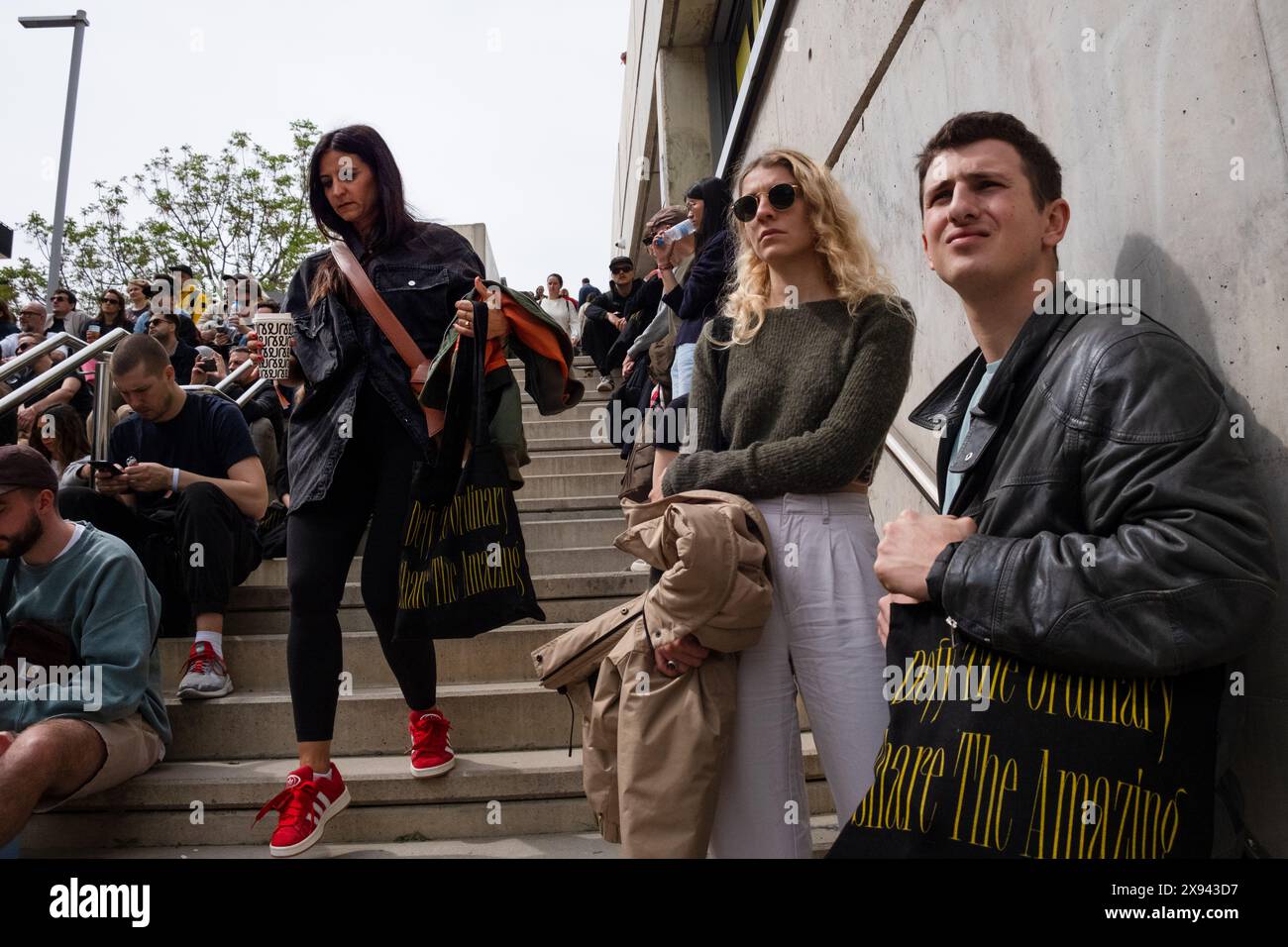 La gente prepara anche i gradini e le scale per cercare di trovare spazio per guardare i discorsi più popolari sugli schermi esterni dell'OFFF Barcelona al Disseny Hub Museum of Design di Barcellona, Spagna, nell'aprile 2024. Figura: Rob Watkins. INFO: La popolare conferenza annuale lanciata nel 2001 è la più grande vetrina al mondo di creatività visiva e design contemporaneo. Attrae designer, artisti, registi e fotografi da tutto il mondo e funge da piattaforma globale per lo scambio creativo e la collaborazione. Foto Stock