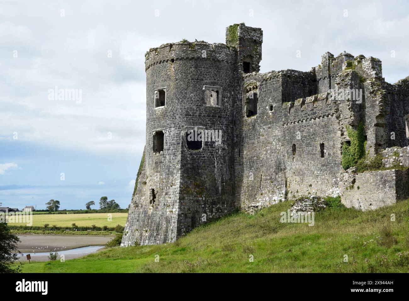 Il castello di Carew, in Galles, offre una vista esterna sul vicino fiume ed è un punto di interesse storico da visitare per i turisti Foto Stock