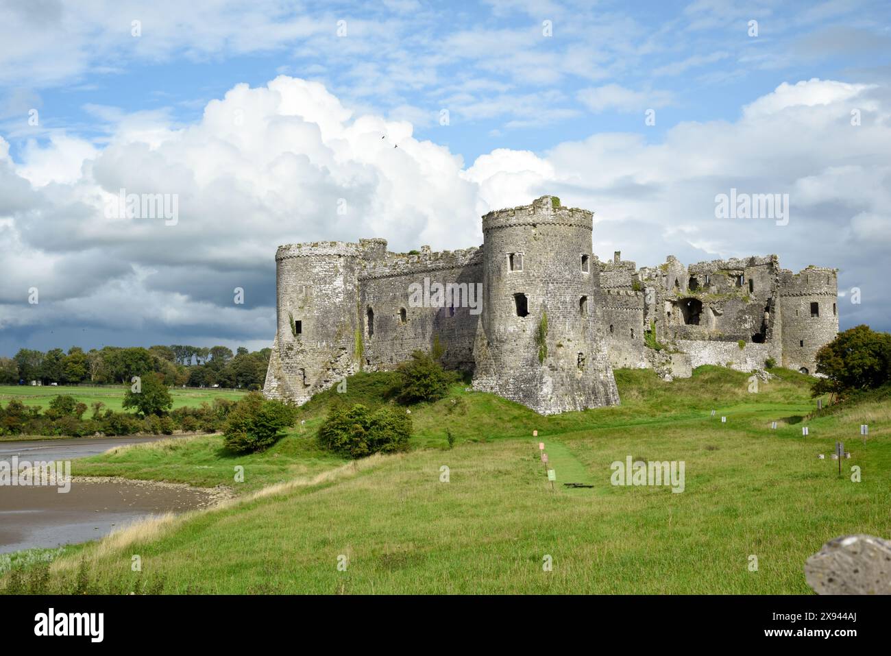 Il castello di Carew, in Galles, offre una vista esterna sul vicino fiume ed è un punto di interesse storico da visitare per i turisti Foto Stock