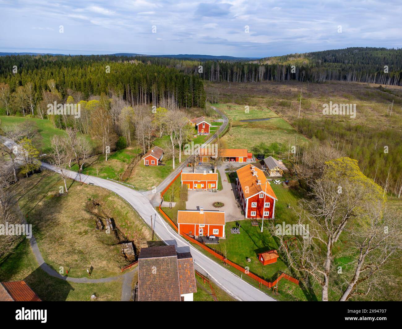 Vista aerea di un villaggio di campagna con edifici arancioni circondati da lussureggiante vegetazione, catturando il fascino rurale. Foto Stock